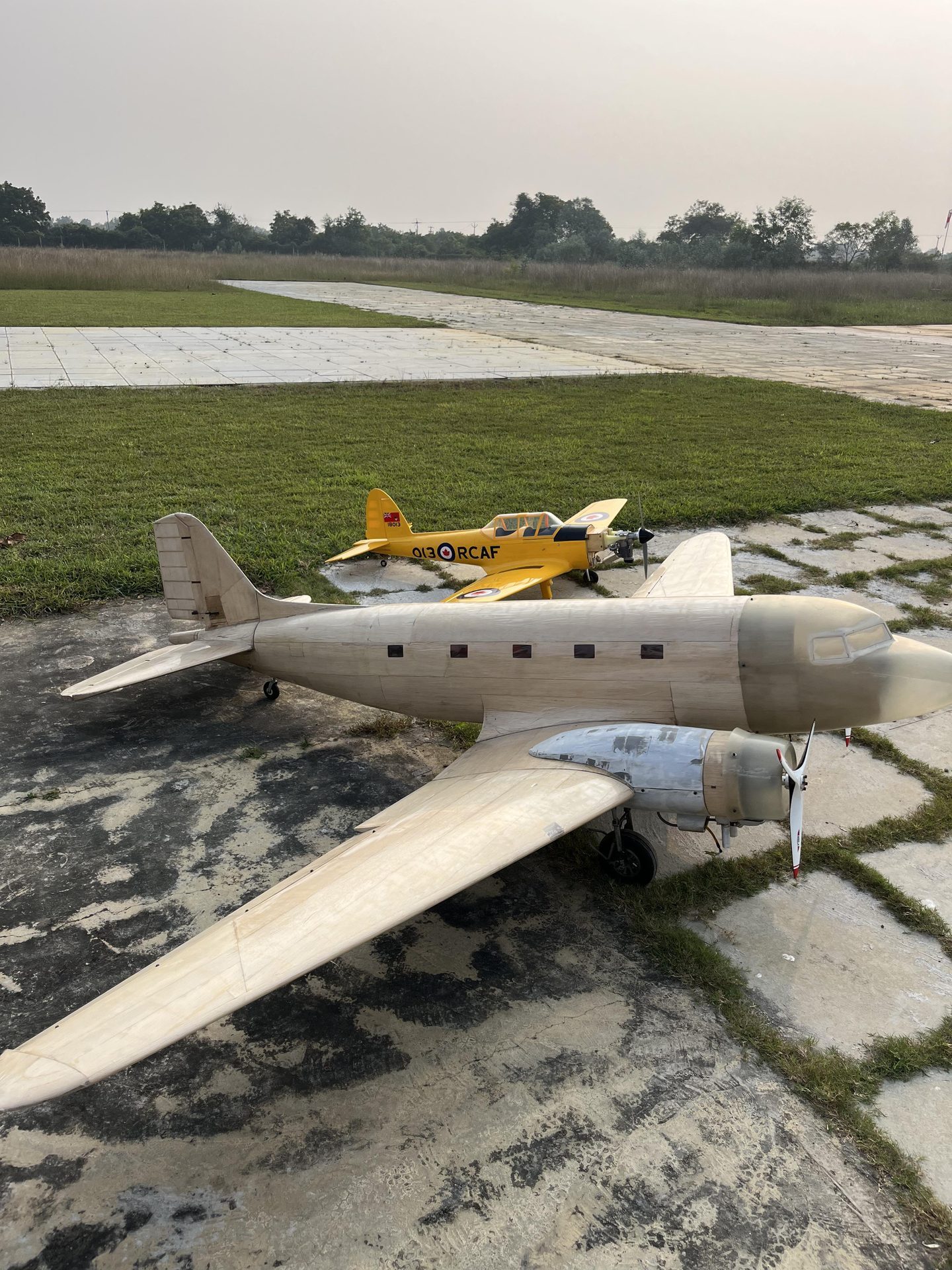 Large DC-3 and trainer RC aircraft at airfield